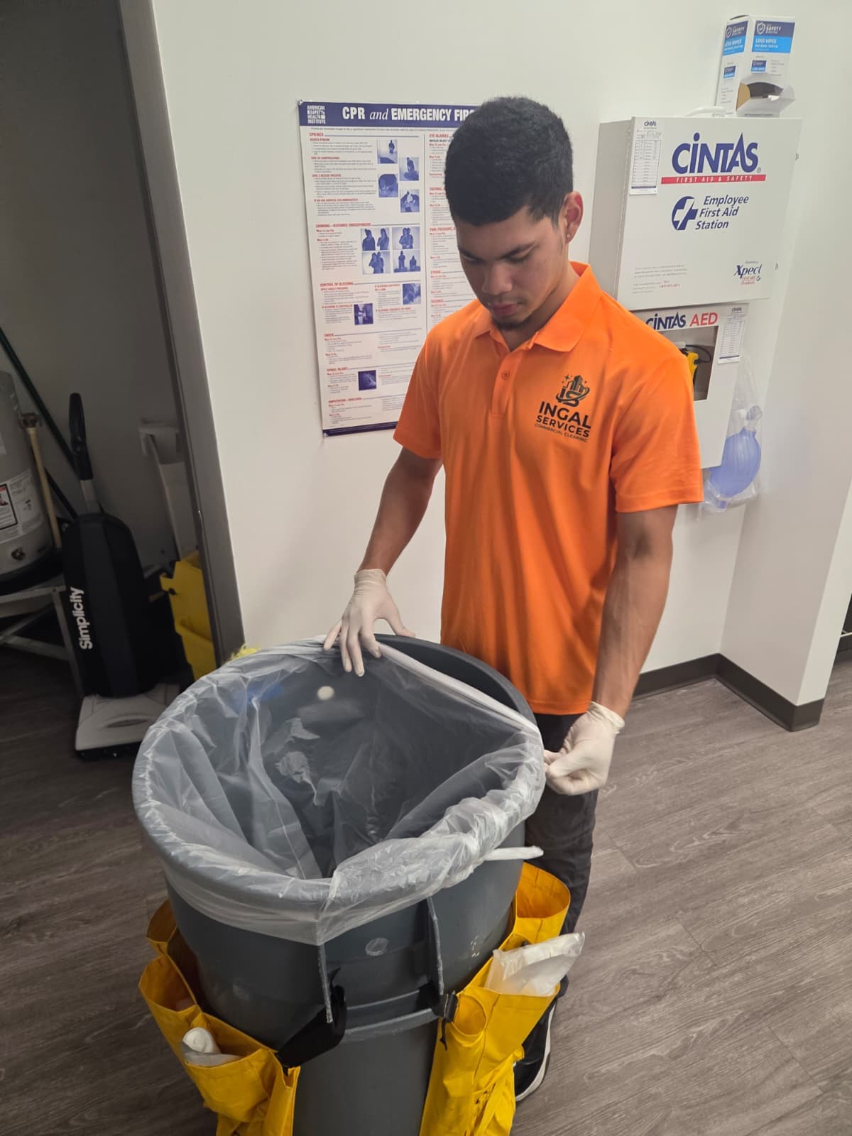 An INGAL SERVICES INC employee preparing a barrel cart beside the employee first aid station at a client site